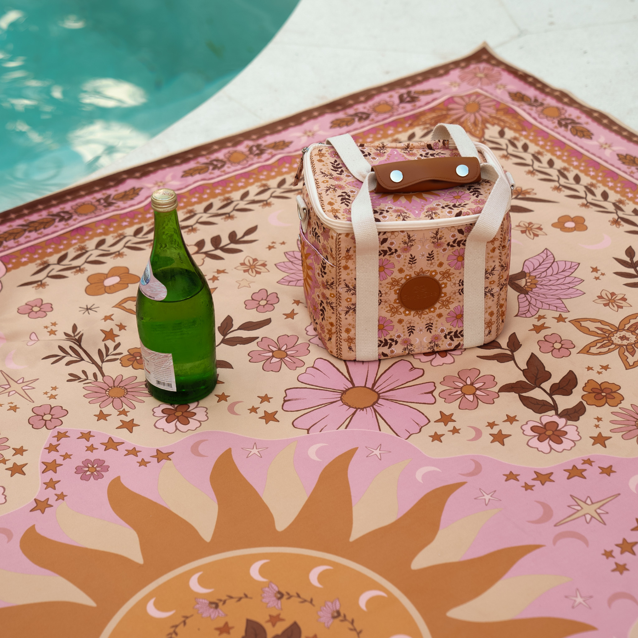 Floral-patterned boho cooler with a bottle by a poolside
