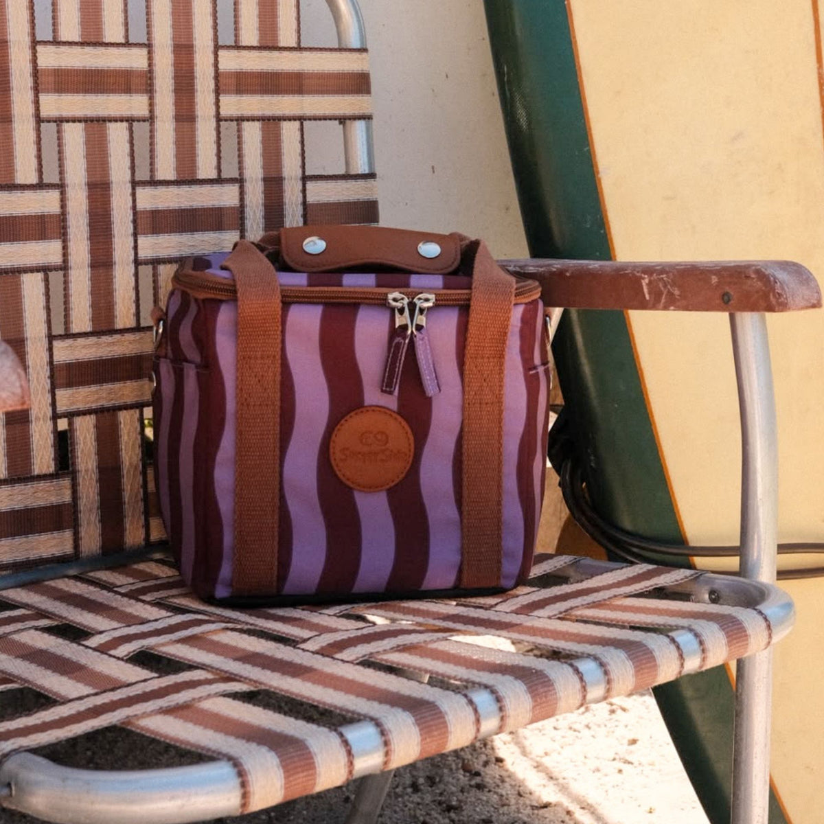 Jagger Shiraz mini insulated cooler bag, burgundy and mauve wavy stripe, on a retro camp chair