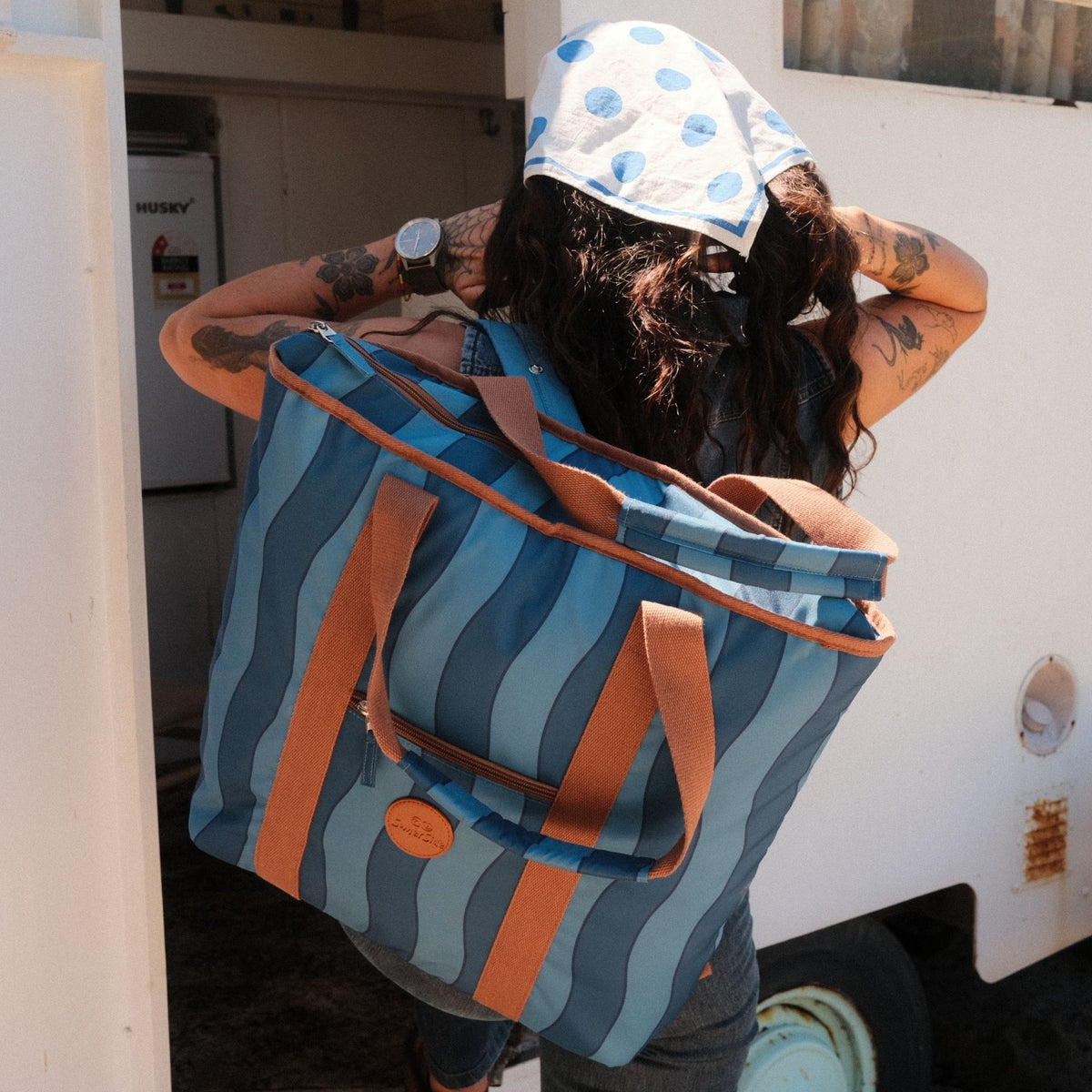 Jagger Tidal beach tote bag, two-tone blue wavy stripe, worn as a backpack