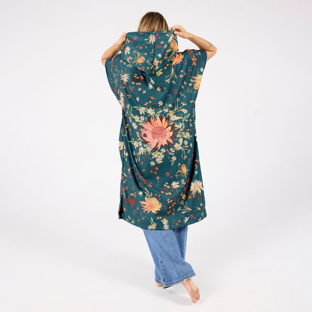 Native Botanical adult hooded towel poncho, dark green Australian wildflower print, back view on model
