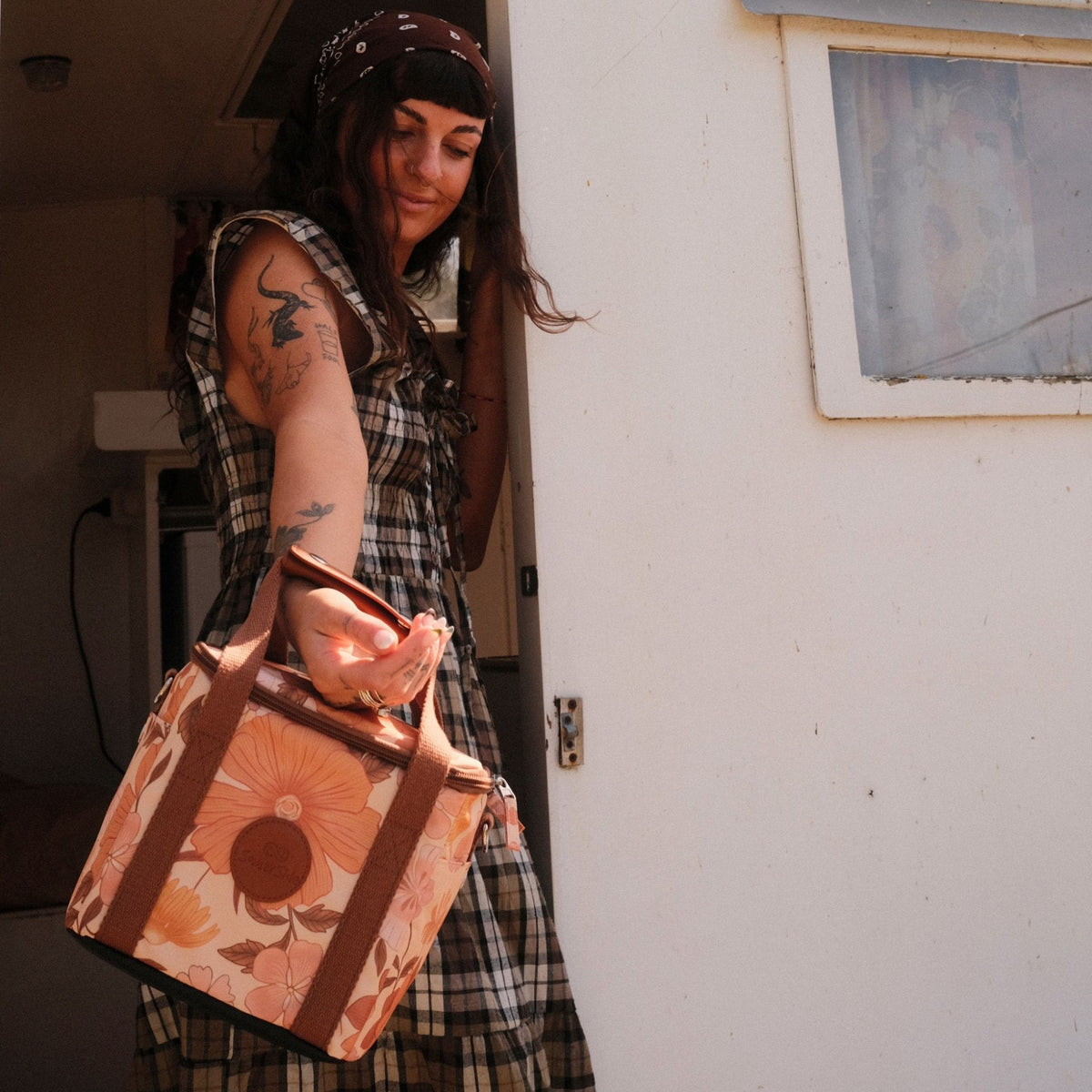 Summer Muse mini insulated cooler bag, peach retro 70s floral print, carried at a caravan