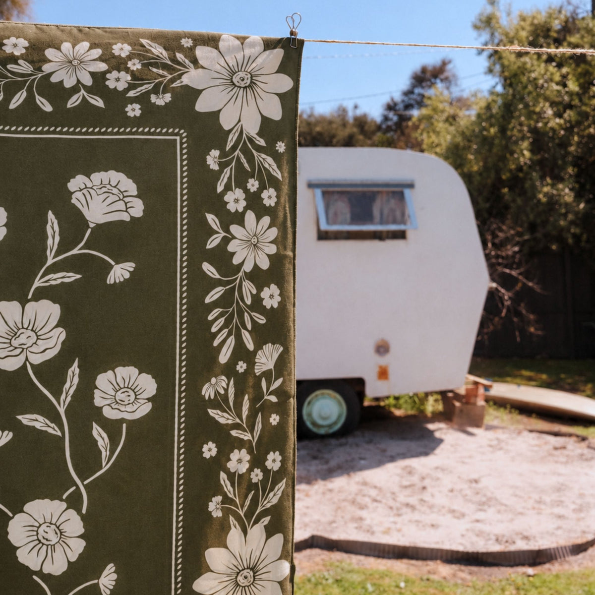 Eden sand free beach towel in Large, olive green floral bandana print, on a washing line, close up