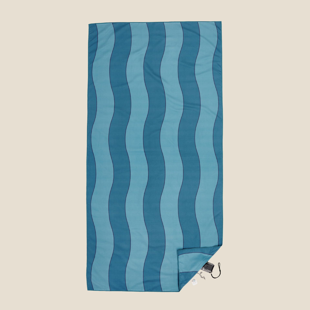 Jagger Tidal sand free beach towel in Large, two-tone blue wavy stripe, studio flat lay