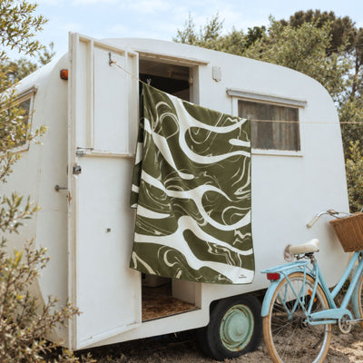 Liquid Dreams sand free beach towel in Large, green and cream marble swirl print, hung on a caravan, side view