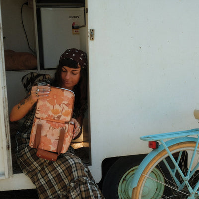 Summer Muse mini insulated cooler bag, peach retro 70s floral print, opened in a caravan doorway