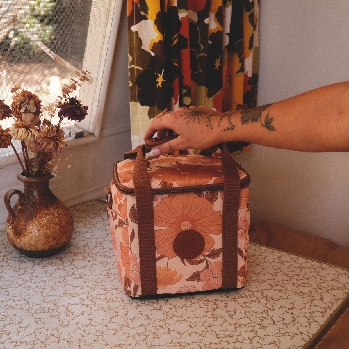 Summer Muse mini insulated cooler bag, peach retro 70s floral print, on a retro table