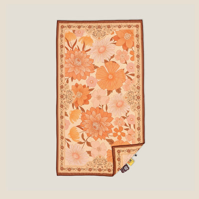 Summer Muse sand free beach towel in Large, peach retro 70s floral print, studio flat lay
