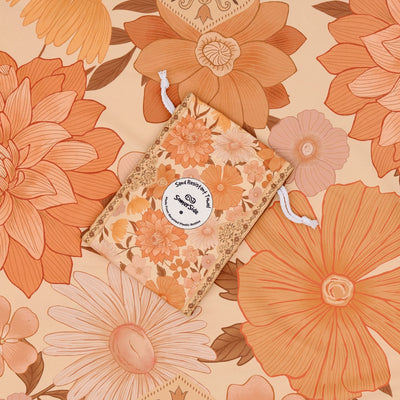 Summer Muse sand free beach towel in Large, peach retro 70s floral print, with its carry pouch