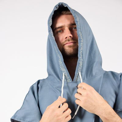 Venice adult hooded towel poncho, dusty blue paisley bandana print, on model with hood up