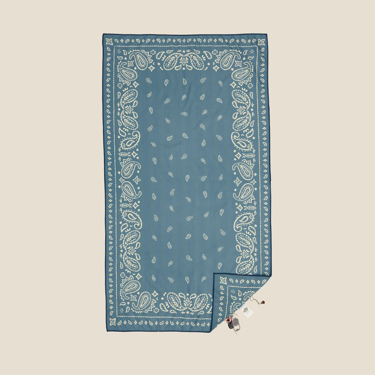 Venice sand free beach towel in Large, dusty blue paisley bandana print, studio flat lay